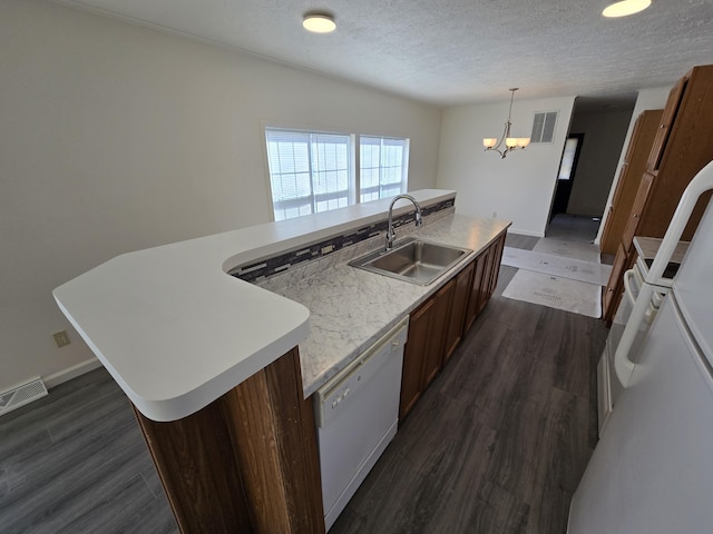kitchen with light countertops, dishwasher, visible vents, a sink, and a chandelier