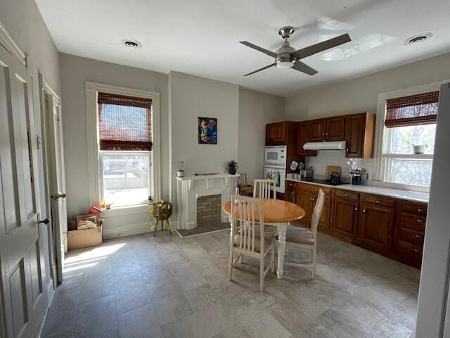 142 Old Lafayette Ave, Lexington, KY 40502 - kitchen with visible vents, ceiling fan, white microwave, under cabinet range hood, and light countertops