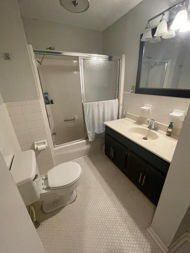 142 Old Lafayette Ave, Lexington, KY 40502 - full bathroom featuring tile walls, toilet, shower / bath combination with glass door, tile patterned floors, and vanity