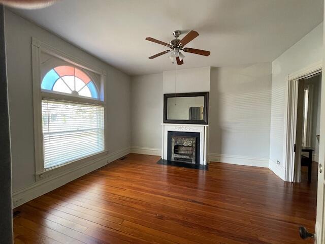 142 Old Lafayette Ave, Lexington, KY 40502 - unfurnished living room featuring baseboards, ceiling fan, a fireplace with flush hearth, and hardwood / wood-style flooring