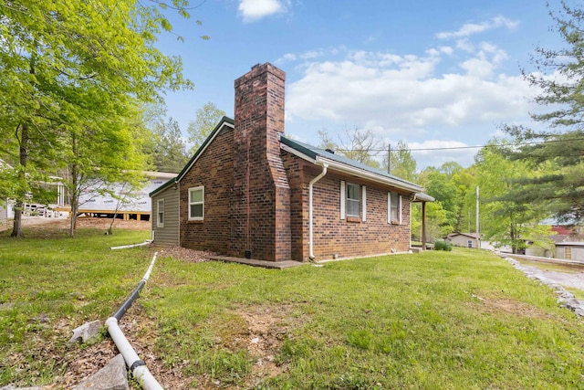 view of home's exterior with a lawn, a chimney, and brick siding