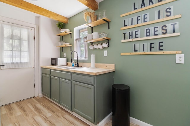 bathroom with baseboards, vanity, wood finished floors, and beamed ceiling