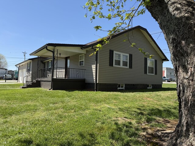 21 N Gregory St, Monticello, KY 42633 - view of side of home with covered porch and a lawn