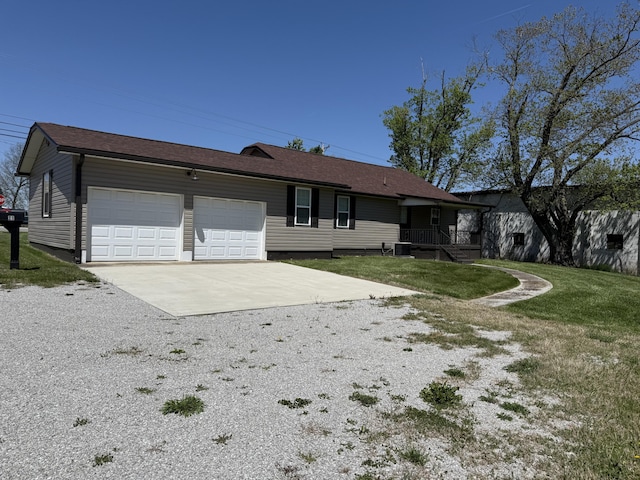 21 N Gregory St, Monticello, KY 42633 - view of front facade with central air condition unit, a garage, gravel driveway, and a front lawn