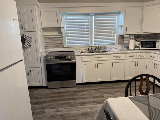 21 N Gregory St, Monticello, KY 42633 - kitchen featuring dark wood finished floors, white appliances, white cabinets, light countertops, and a sink