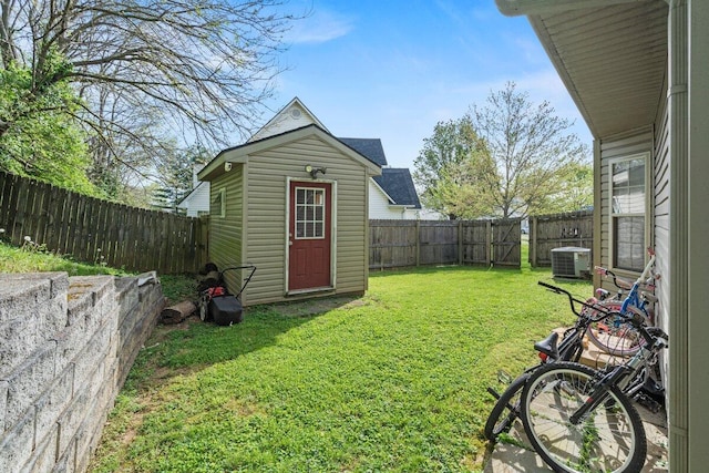 view of yard featuring a fenced backyard, central AC unit, an outbuilding, and a shed
