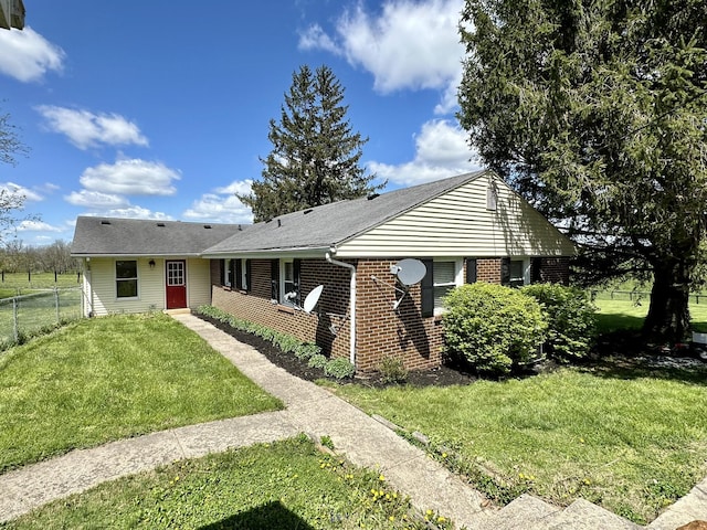 view of front of house with fence, a front yard, and brick siding