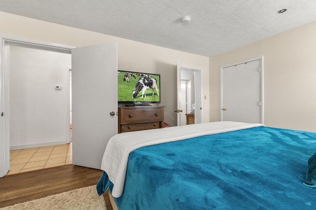 bedroom featuring a textured ceiling and wood finished floors