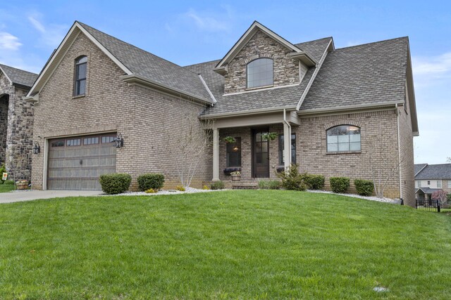 view of front of house featuring a front lawn, driveway, a shingled roof, an attached garage, and brick siding