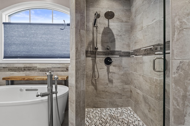 bathroom with a freestanding tub and a stall shower