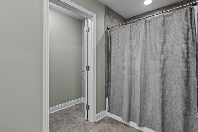 bathroom featuring baseboards and a shower with curtain