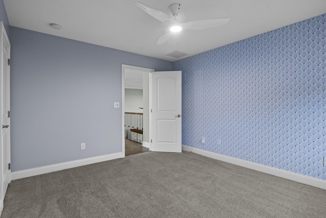 unfurnished bedroom featuring carpet floors, wallpapered walls, and baseboards