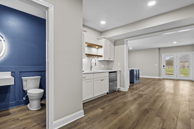 kitchen with dark wood-style floors, a sink, white cabinetry, open shelves, and light countertops