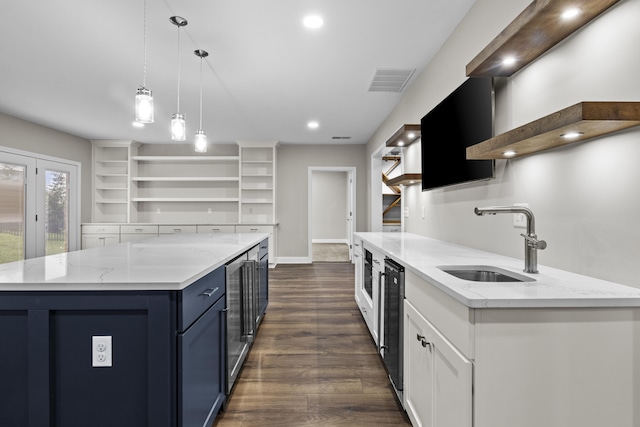 kitchen with blue cabinets, dark wood-style floors, a sink, visible vents, and open shelves