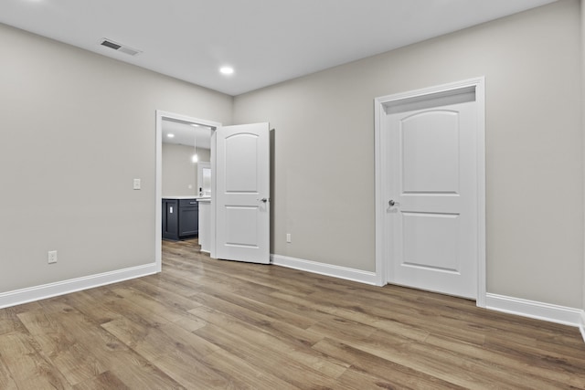 unfurnished bedroom featuring baseboards, visible vents, recessed lighting, and light wood-style floors