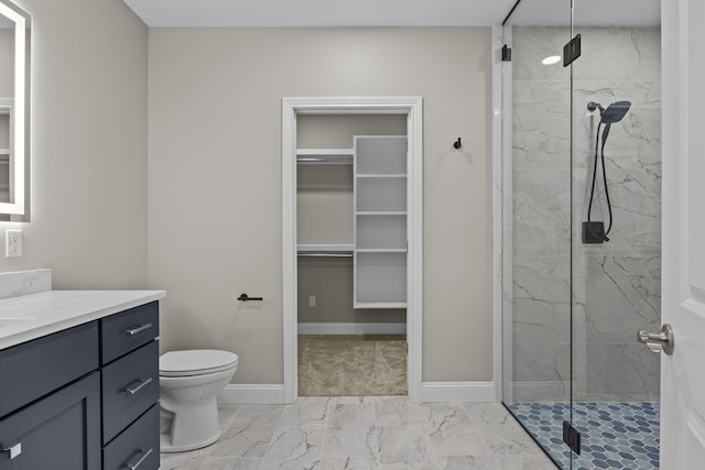 bathroom with marble finish floor, a spacious closet, vanity, and a marble finish shower