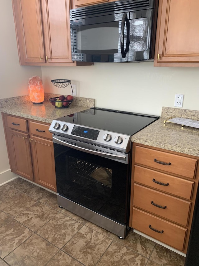 650 S Mill St Unit 218, Lexington, KY 40508 - kitchen with black microwave, stainless steel range with electric stovetop, light countertops, and brown cabinetry