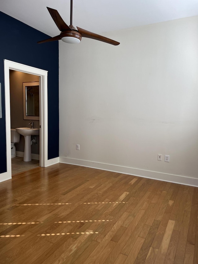 650 S Mill St Unit 218, Lexington, KY 40508 - unfurnished bedroom featuring wood finished floors, baseboards, a sink, ceiling fan, and connected bathroom