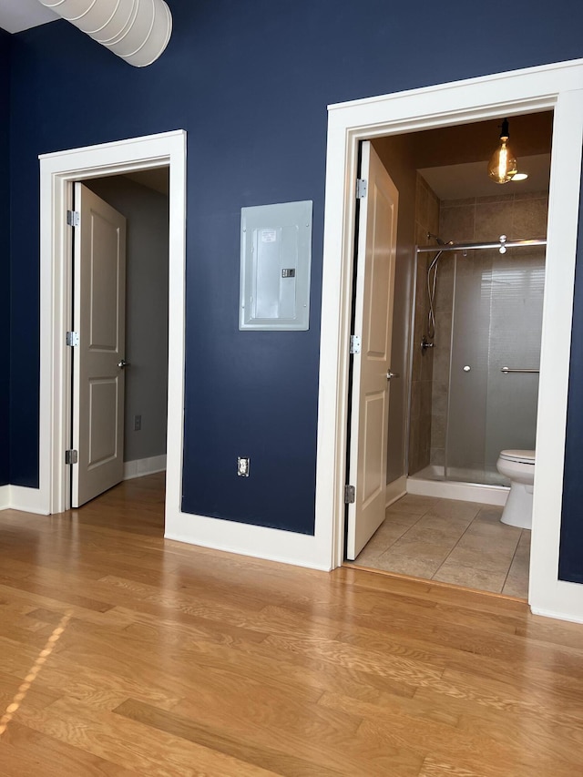 650 S Mill St Unit 218, Lexington, KY 40508 - bathroom featuring electric panel, a stall shower, wood finished floors, and toilet