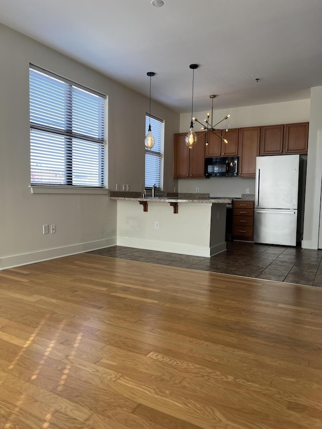 650 S Mill St Unit 218, Lexington, KY 40508 - kitchen featuring freestanding refrigerator, black microwave, dark wood finished floors, and a breakfast bar