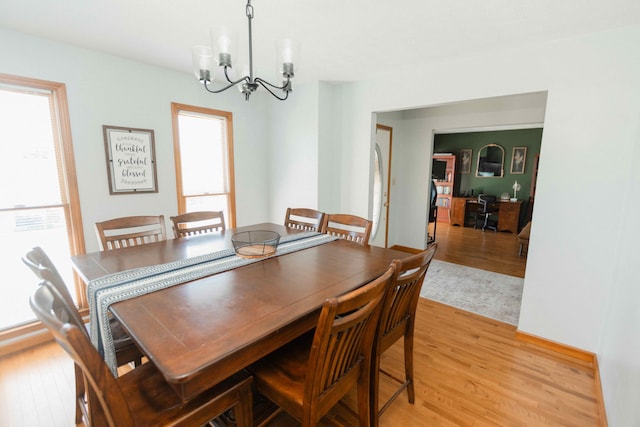 dining room with light wood finished floors and an inviting chandelier