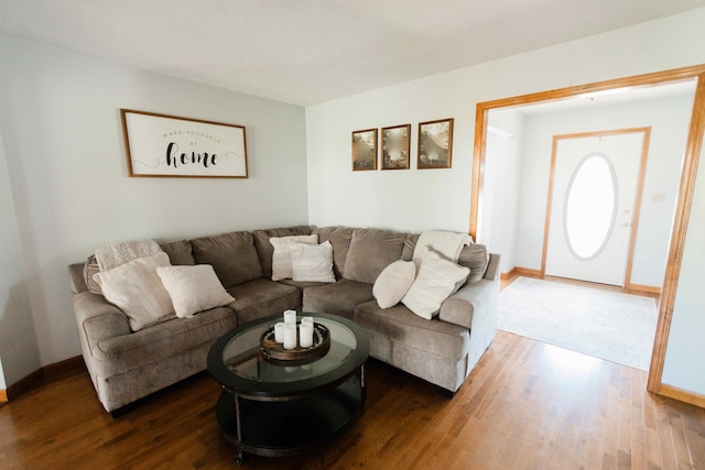 living area featuring baseboards and dark wood-style flooring