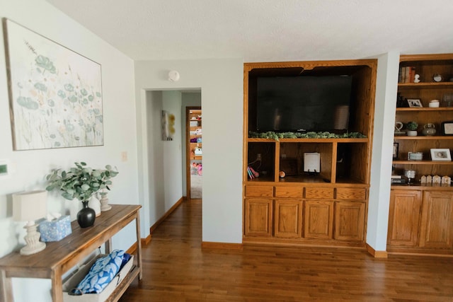 living room featuring baseboards, wood finished floors, and a textured ceiling