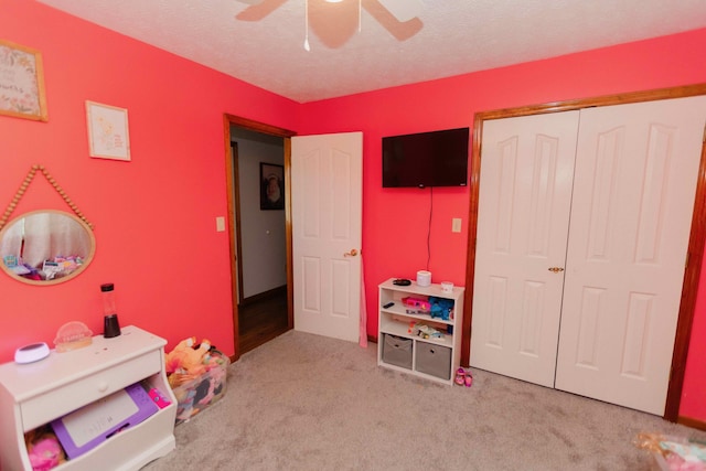 recreation room featuring carpet, a textured ceiling, and ceiling fan