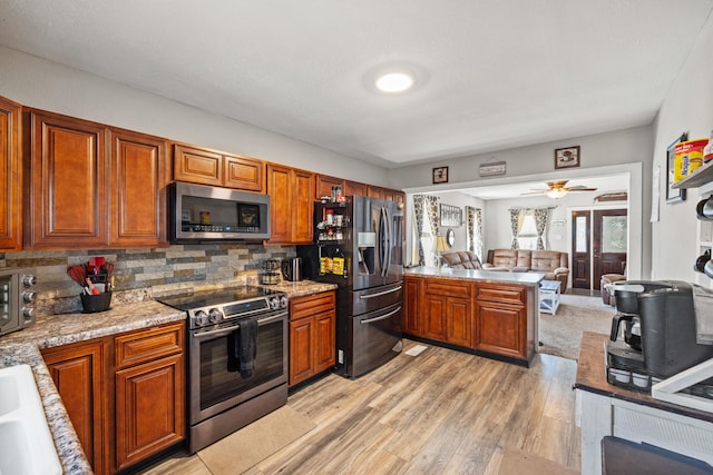 100 Lair St, Mount Vernon, KY 40456 - kitchen with stainless steel appliances, a peninsula, light wood-style floors, backsplash, and brown cabinets