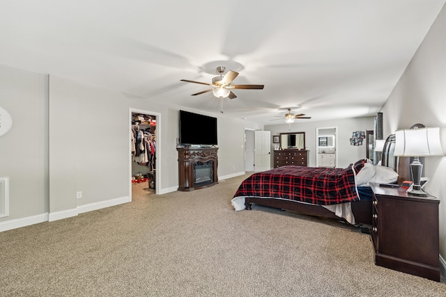 100 Lair St, Mount Vernon, KY 40456 - bedroom with a walk in closet, carpet flooring, a glass covered fireplace, baseboards, and ceiling fan
