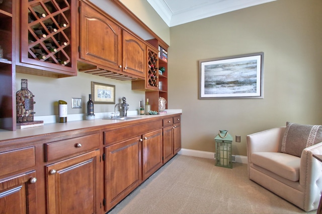 bar with crown molding, baseboards, a sink, and light colored carpet