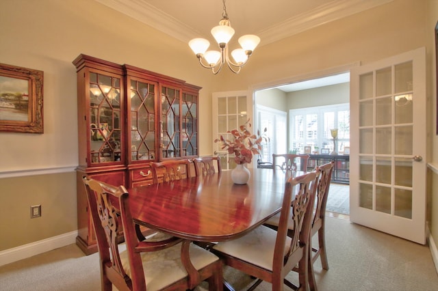 carpeted dining room featuring crown molding, baseboards, an inviting chandelier, and french doors