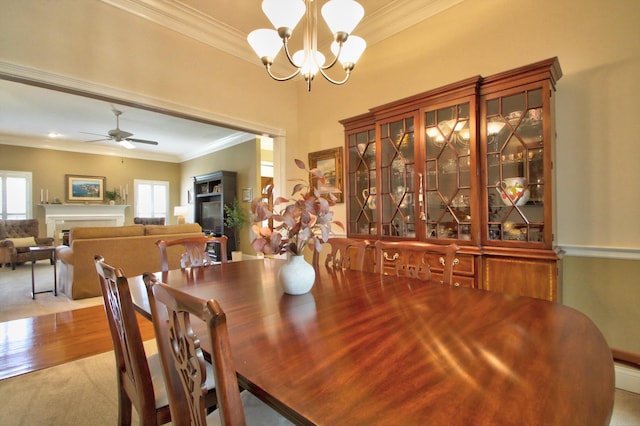 dining area with plenty of natural light, ornamental molding, and a fireplace