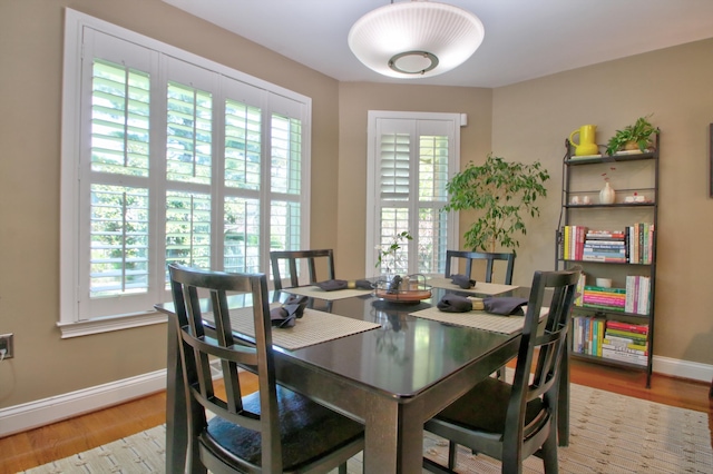 dining space featuring baseboards and wood finished floors