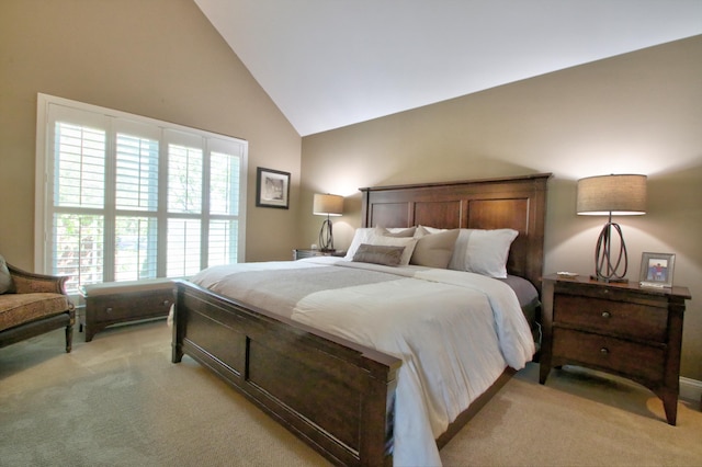 bedroom with light colored carpet and high vaulted ceiling