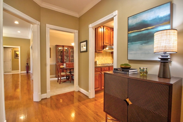 hallway with crown molding, recessed lighting, baseboards, and light wood-style floors