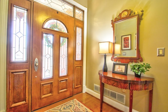 entrance foyer with a healthy amount of sunlight, baseboards, and wood finished floors