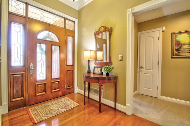 entryway featuring baseboards, ornamental molding, and wood finished floors