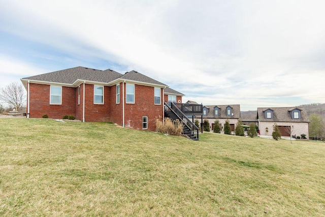 exterior space with stairs, brick siding, and a lawn