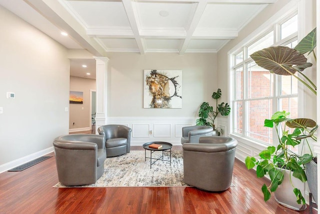 living area with visible vents, ornate columns, wood finished floors, and beamed ceiling
