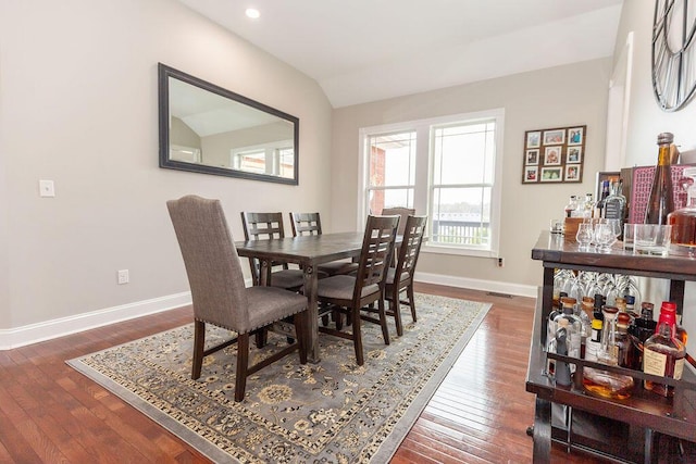 dining space with hardwood / wood-style floors, baseboards, lofted ceiling, and recessed lighting