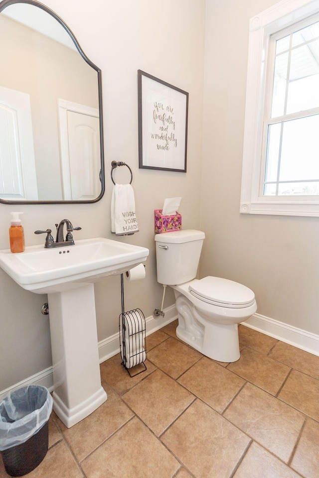 bathroom with tile patterned floors, baseboards, a sink, and toilet