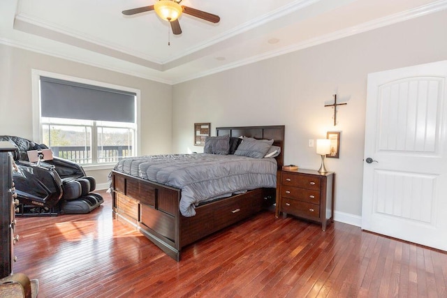 bedroom with baseboards, a ceiling fan, crown molding, hardwood / wood-style floors, and a raised ceiling