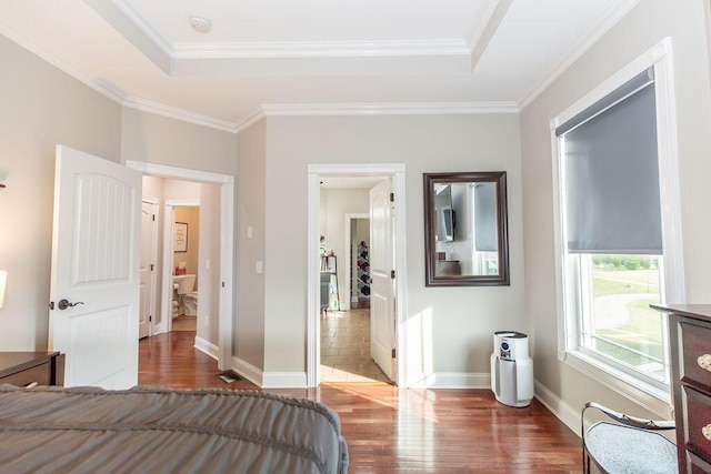 bedroom with crown molding, baseboards, and wood finished floors