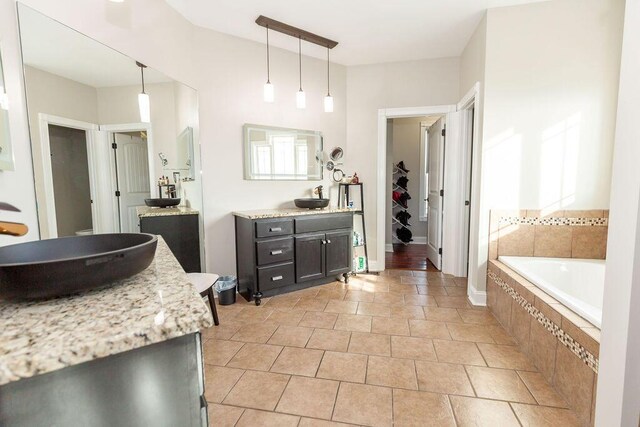 bathroom with tile patterned floors, a garden tub, and vanity