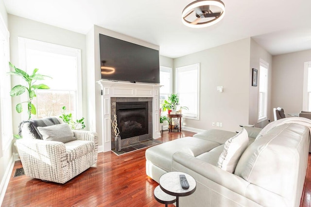 living room with visible vents, baseboards, hardwood / wood-style flooring, and a fireplace