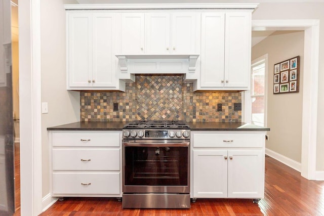 kitchen featuring tasteful backsplash, dark wood-style flooring, baseboards, dark countertops, and stainless steel range with gas cooktop
