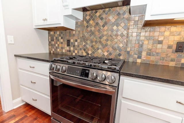 kitchen featuring range hood, dark countertops, stainless steel range with gas cooktop, and dark wood-style floors