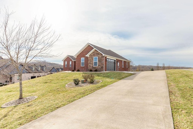 ranch-style home featuring a garage, a front yard, brick siding, and driveway