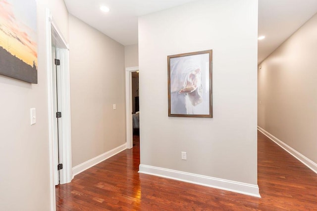 hallway featuring wood finished floors, baseboards, and recessed lighting